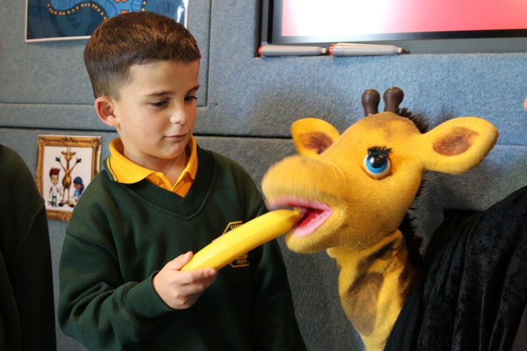 Student feeding Healthy Harold a banana.