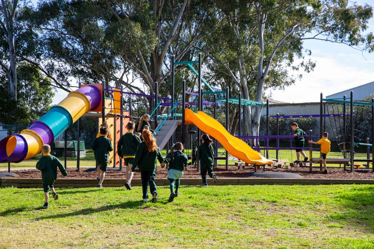 Students running towards the playground equipment.