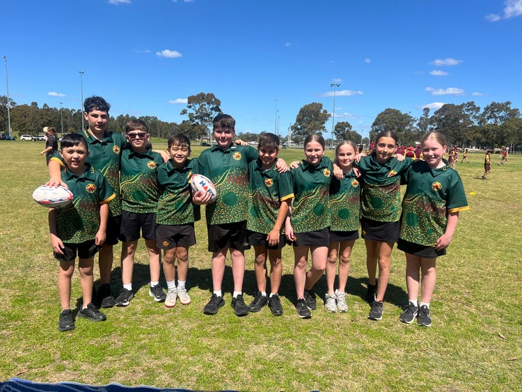 Students wearing sports uniform posing for a photo at a sporting event.