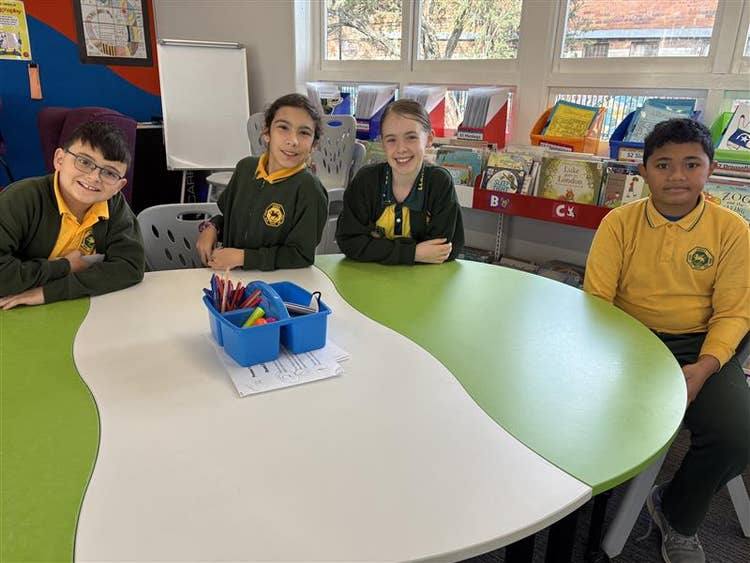 Students sitting at a green table.